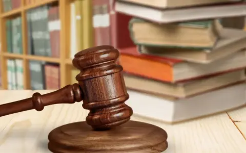 Martelletto da giudice su tavolo di legno, con libri e scaffali sullo sfondo. Simboleggia cosa succede dopo incidente probatorio.