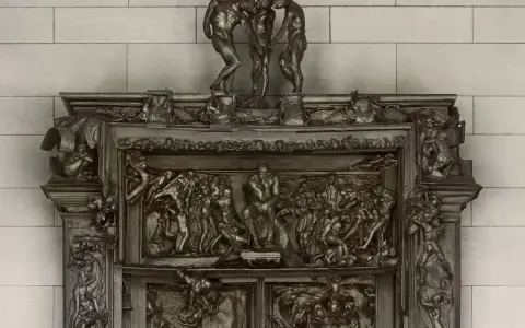 Detaljerad bronsrelief av helvetets portar, med figurer i dramatiska poser.