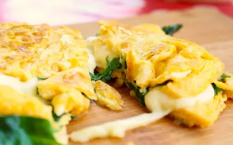 Gefülltes Omelett mit geschmolzenem Käse und Spinat, perfekt für einfache Outdoor-Gerichte.