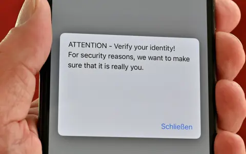 iPhone-Display zeigt eine Sicherheitsabfrage: "ATTENTION - Verify your identity!". Ein Virenscan könnte dies auslösen.