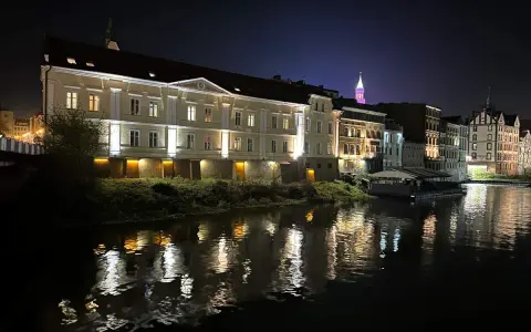 Nocna panorama miasta nad rzeką, z oświetlonymi kamienicami i odbiciami świateł w wodzie. To prawdziwa opolska wenecja.