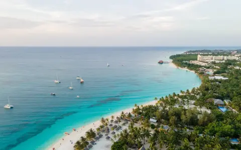 Rajska plaża na Zanzibarze z turkusową wodą, łodziami i luksusowymi hotelami. Sprawdź Zanzibar ceny i zaplanuj wymarzone wakacje!
