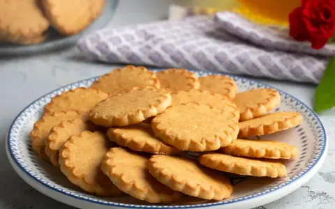 Stos pysznych, szybkich kruchych ciasteczek na talerzu z niebieskim wzorem. Idealne na podwieczorek.