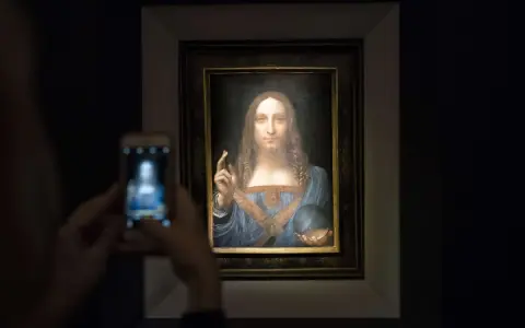 Persona toma foto a Salvator Mundi, el cuadro más caro del mundo, con su móvil.