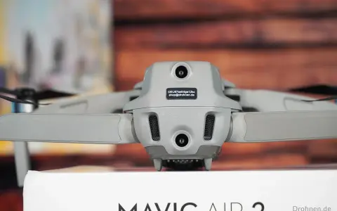 Graue Drohne Mavic Air 2 mit Kameras und Propellern. Auf dem Gehäuse ist ein Aufkleber mit der Kennung zur drohne registrieren.