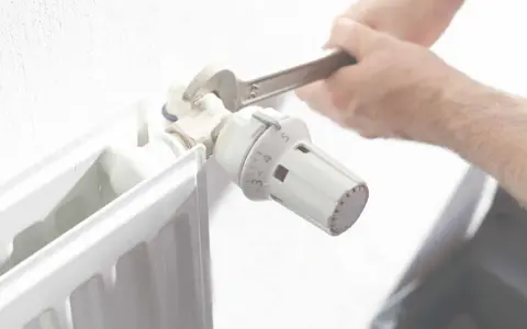 Ajustando el termostato de un radiador. Averigua cuanto cuesta una hora de calefacción de gas natural para optimizar tu consumo.