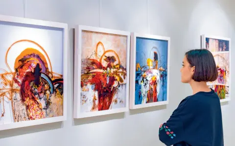 Kobieta ogląda abstrakcyjne obrazy w galerii sztuki.