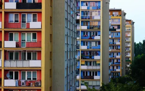 Rząd kolorowych bloków mieszkalnych z balkonami.