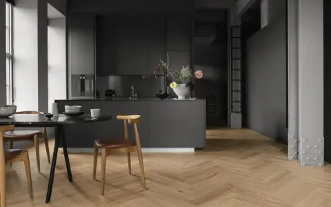 Cuisine moderne avec îlot central, chaises en bois et table en marbre. Le parquet en chevrons, bien que beau, est une mauvaise idée pour une cuisine.