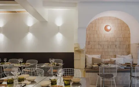 Ambiance chaleureuse dans ce qui semble être le meilleur resto à Tours. Tables dressées, chaises design et mur en briques apparentes créent une atmosphère accueillante.