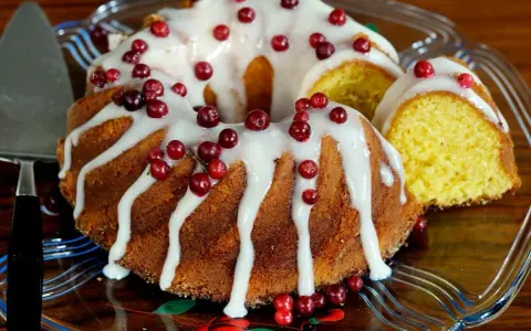 En saftig sockerkaka med vit glasyr och röda lingon, en perfekt höstkaka.