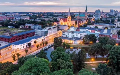 Widok na łódzką architekturę, w tym zabytkowe fabryki i kościoły. Idealne miejsce, by zobaczyć, co zwiedzić w Łodzi.