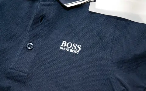 Granatowa koszulka polo z haftowanym logo BOSS HUGO BOSS. Widoczna oryginalna metka Hugo Boss.