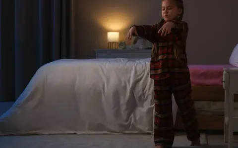 Bambina in pigiama a quadri cammina nel sonno, un esempio di sonnambulismo bambini.