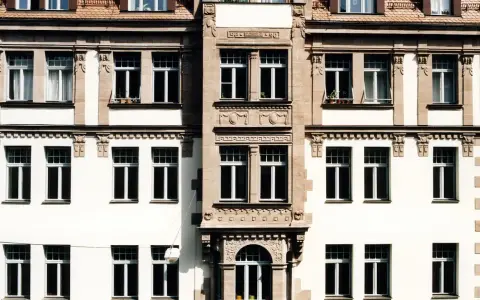 Fassade eines Altbaus mit vielen Fenstern. Hier könnte eine energetische Sanierung Beratung ansetzen, um das Gebäude fit für die Zukunft zu machen.