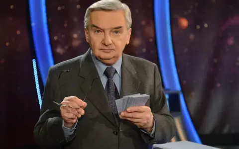 Starszy mężczyzna w garniturze trzyma okulary i karty z napisem "jeden z dziesięciu kiedy".
