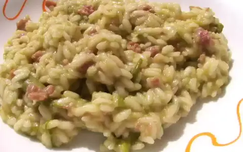 Un cremoso risotto asparagi e salsiccia, un piatto ricco di sapore e colore, pronto per essere gustato.