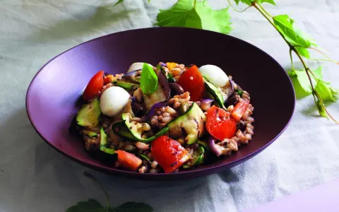 Insalata di farro estiva con verdure grigliate, pomodorini, mozzarelline e basilico fresco.