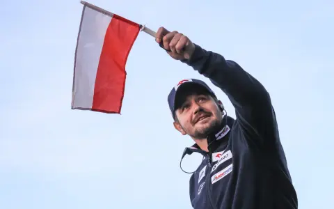 Radosny kibic z polską flagą na skoki narciarskie mistrzostwa świata juniorów.
