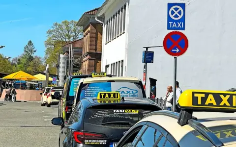 Taxistand mit Schildern. Was kostet eine Taxifahrt von 30 km? Die Schilder geben keine Auskunft über Preise.