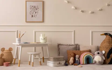 Ein Kinderzimmer mit einem kleinen Schreibtisch, Spielzeug und einem Bild mit der Aufschrift "Small steps every day". Eine beige Mom würde sich hier wohlfühlen.