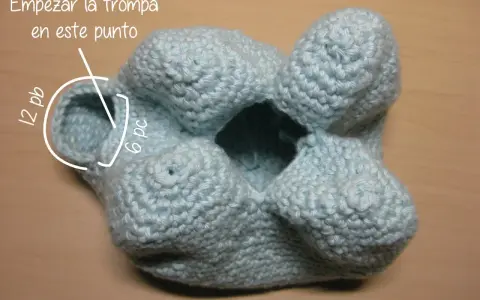 Un elefante amigurumi azul claro, en proceso de tejido. Se indica dónde empezar la trompa.