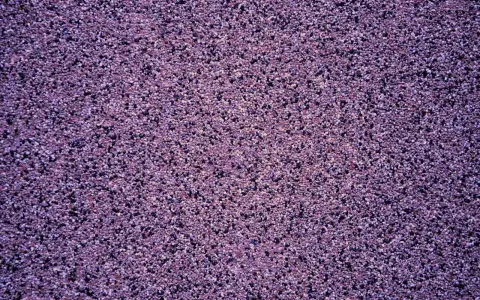 Fioletowy tynk mozaikowy o drobnej granulacji. Wydajność 25 kg na ok. 3-4 m², zależnie od grubości warstwy.