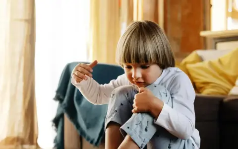 Chłopiec zamyślony, przytula kolana. Czy to może być co to jest tik?