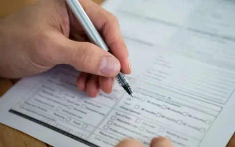 Dłoń z długopisem wypełnia formularz. Warto wiedzieć, jak znaleźć numer NIP, by poprawnie uzupełnić dokumenty.