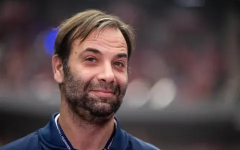 Uśmiechnięty Ivano Balić, legenda piłki ręcznej, z charakterystyczną brodą i zmierzwionymi włosami.
