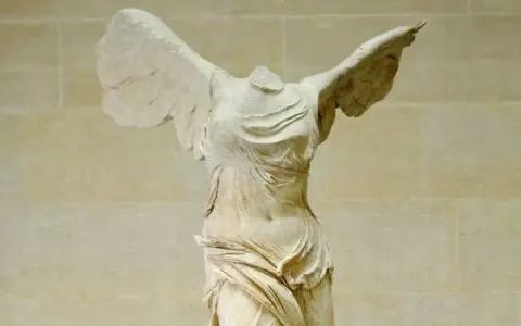 La Victoire de Samothrace, statue grecque antique sans tête, ailes déployées, drapé flottant.