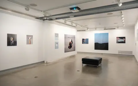 Art exhibition at blue sky gallery Portland, featuring abstract photography and a black leather ottoman.