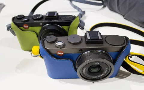 Dwie stylowe Leica X2 w kolorowych futerałach: jedna zielona, druga niebieska. Idealne do uchwycenia każdej chwili.