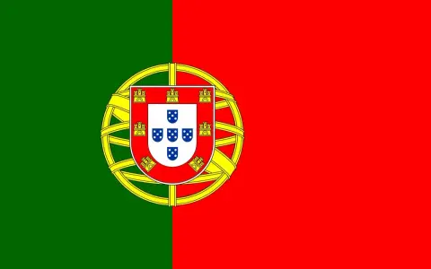 Flaga Portugalii z zielono-czerwonym podziałem i tarczą herbową z zamkami i tarczkami z pięcioma niebieskimi tarczkami.