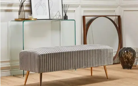 En elegant, randig bänk med guldfärgade ben. En billig bänk som ger ditt hem en lyxig känsla.