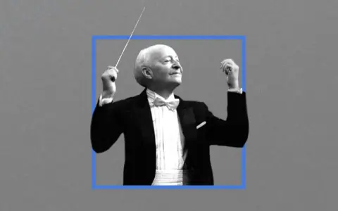 Witold Lutosławski, kompozytor, dyryguje orkiestrą w eleganckim fraku.