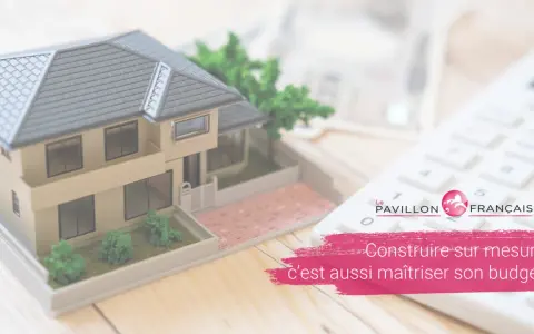 Maquette de maison, calculatrice et billets de banque. Le prêt construction pour construire votre rêve.