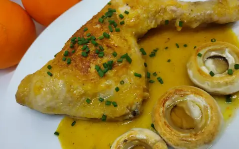 Pollo a la naranja jugoso con salsa cítrica, acompañado de champiñones y cebollino fresco.