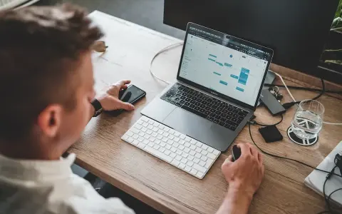 Mężczyzna pracuje przy laptopie, planując zadania. To idealne miejsce do nauki, by rozpocząć kurs spedytora i zdobyć nowe umiejętności.