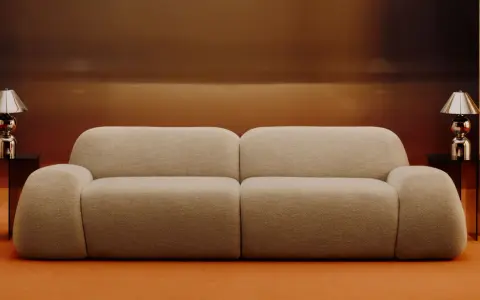 Divano beige bouclé, un materiale morbido e accogliente, con tavolini neri e lampade cromate.