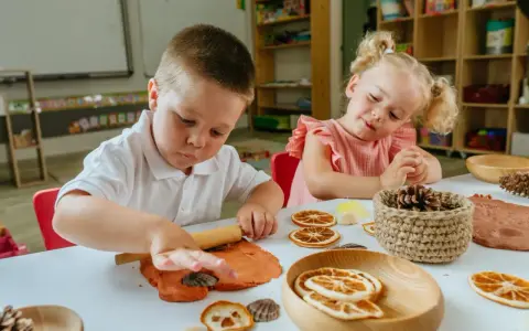 Niños de 3 a 4 años disfrutan de actividades creativas en casa, moldeando arcilla y decorando con elementos naturales.