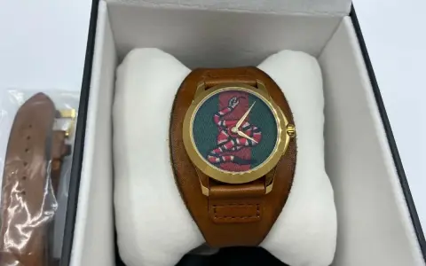 Orologio Gucci serpente con quadrante verde e cinturino in pelle marrone, presentato nella sua scatola.