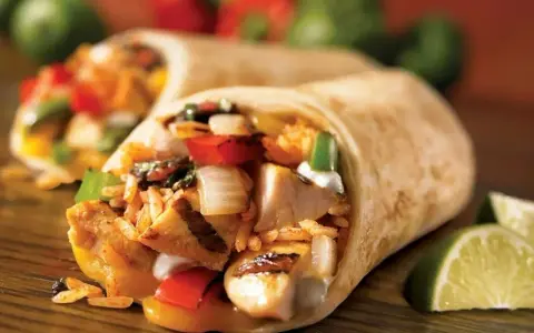Pyszna tortilla z kurczakiem na ciepło, ryżem, warzywami i serem. Idealna na szybki posiłek.