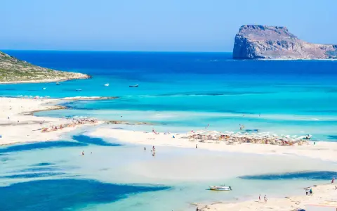 Rajska plaża z turkusową wodą i skalistą wysepką. Czy to Kreta czy Rodos? Niezależnie, widok zapiera dech!