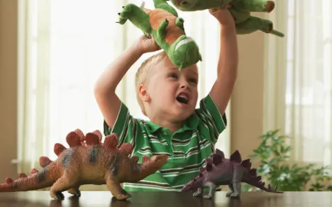 4 letnie dziecko bawi się pluszowymi dinozaurami, wyobrażając sobie prehistoryczną przygodę.