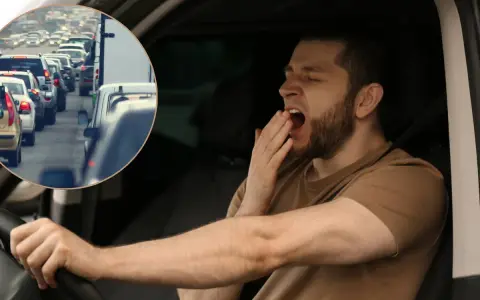 Es peligroso conducir con sueño porque la fatiga reduce la atención y los reflejos, como se ve en este conductor bostezando en medio de un atasco.