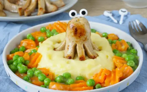 Kreatives Essen für Kinder: Wurst-Oktopus auf Kartoffelbrei mit Erbsen und Karotten. So macht das Backen Spaß!