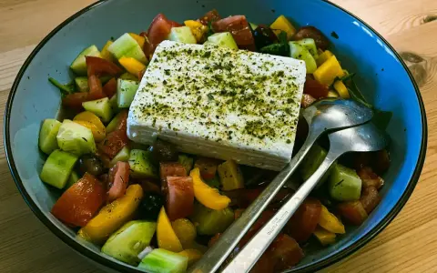 Sałatka grecka z kostką sera feta, pomidorami, ogórkiem i oliwkami. Czy ser feta jest zdrowy? Tak, to pyszny i zdrowy dodatek!