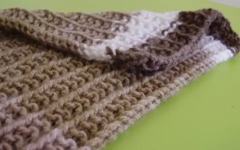 Bufanda tejida con patrones puntos reversibles a dos agujas, en tonos marrones y blanco.
