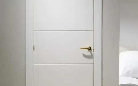 Puerta lacada en blanco con tirador dorado. Aprende como limpiar puertas lacadas en blanco para mantenerlas impecables.